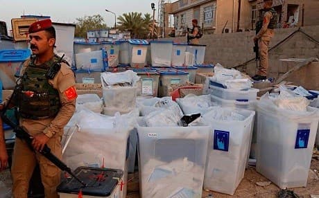 Iraqi security forces guard ballots rescued from a warehouse after fire on June 10. Photo: AP
