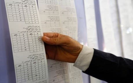 An Iraqi electoral commission official examines electronic counting machine print-outs in Najaf on May 13, 2018. Photo: Haidar Hamdani | AFP