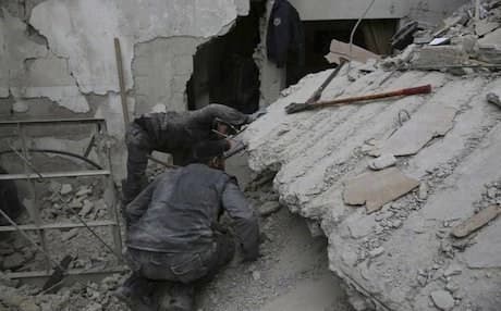 Members of the Syrian Civil Defense group searching for victims under a destroyed building in Ghouta. Photo provided by Syrian Civil Defense White Helmets via AP