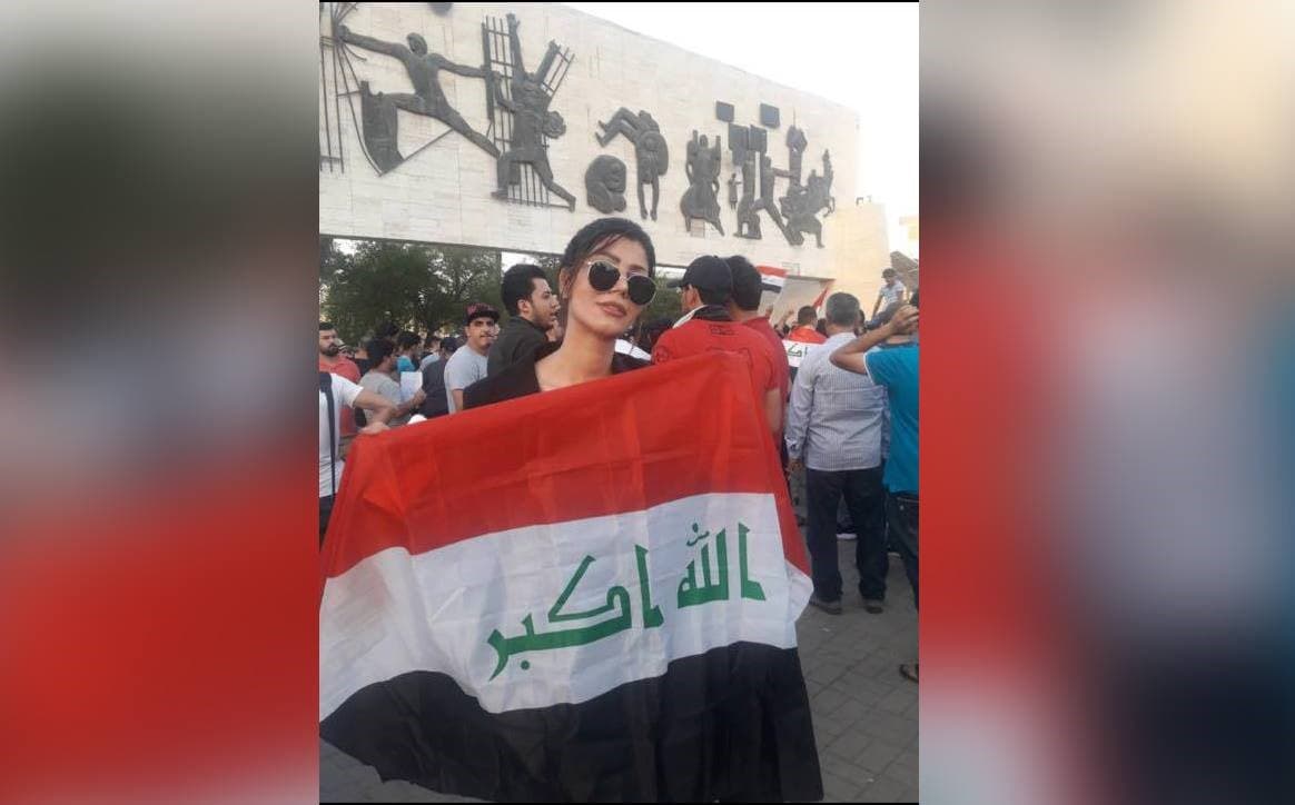 Hannan Mahdi, who has worked as an anchor for state-run Al Iraqiya, holds the flag of the Republic of Iraq during demonstrations in July 2018 in Baghdad. Photo: Rudaw via Hannan Mahdi FB