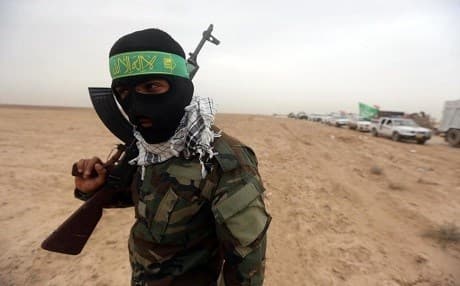 A masked fighter from the Popular Mobilization Forces holds a position on the edge of the Anbar province, northwest of Baghdad, on June 1. Ahmad Al-Rubaye | AFP