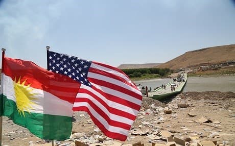 The flags of the Kurdistan Region and the United States fly high in a border crossing between the Kurdistan Region and Syria in the Summer of 2014 after the arrival of some Yezidi survivors who escaped the ISIS attacks against their communities in and around Shingal. File photo: Rudaw