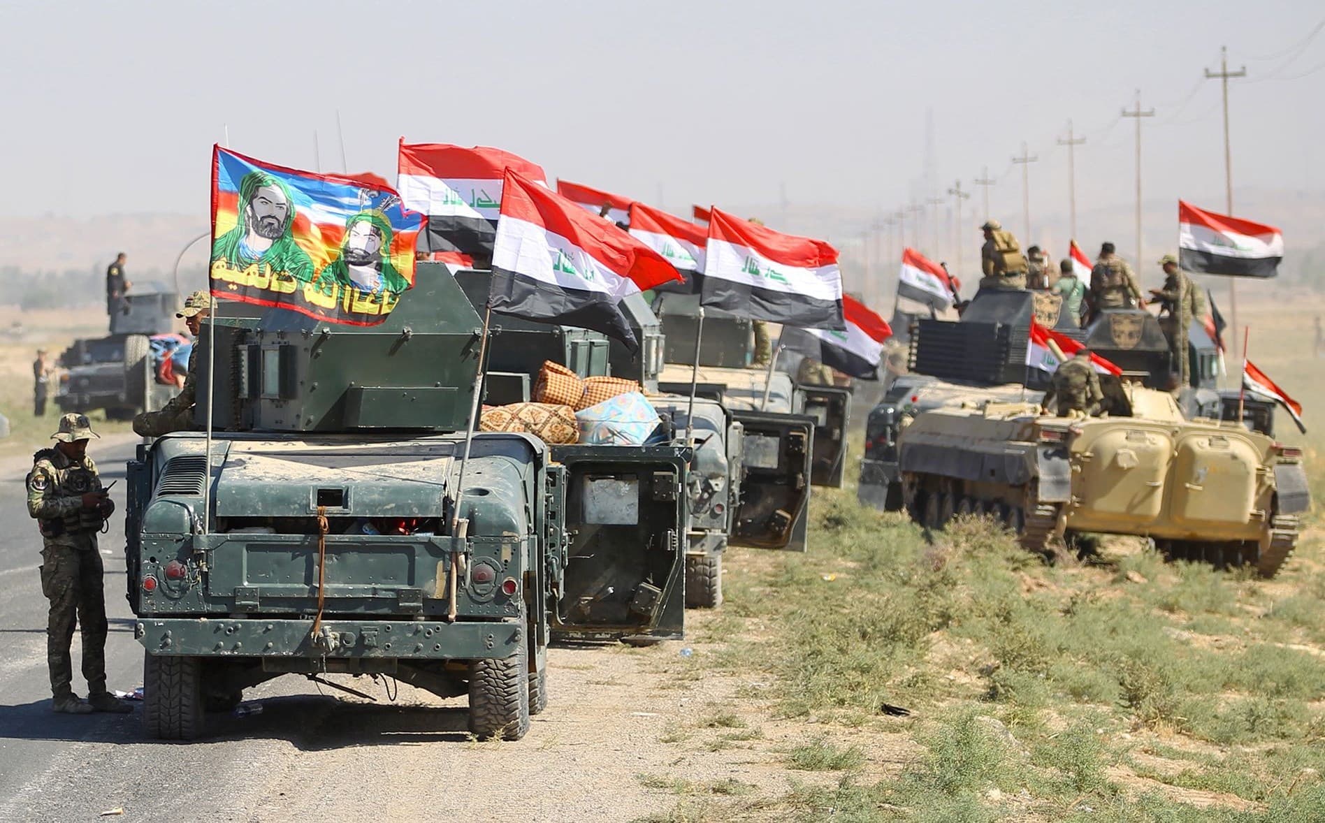 Iraqi troops with religious banners flying atop their vehicles advancing on Kirkuk, Oct. 2017. Photo AFP