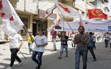 Syrian Christians wave flags of the party during a protest organized by the Syriac Union Party on August 30, 2013 in Qamishli. Photo: Benjamin Hiller | AFP