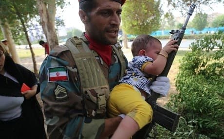 An Iranian soldier carries a child at the site of an attack on a military parade in Iran's southwestern city of Ahvaz on September 22. Photo: Mehdi Pedramkhou/Mehr News/AFP