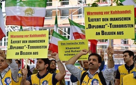 Activists of the National Council of Resistance of Iran (NCRI) hold placards reading 'Deliver the Iranian diplomat - terrorist to Belgium' during a demonstration calling for the extradition of a secret service officer to Belgium in front of the Federal Foreign Office in Berlin on July 11, 2018. Photo: Tobias Schwarz | AFP