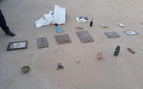 Rare antiquities, weapons, and prohibited items recovered from a house raid in west Mosul. Photo: Nineveh Police Command / Facebook