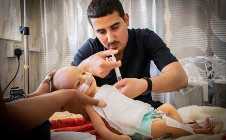 A three-day-old baby, suffering from a high fever and low sugar levels, is treated in the emergency room of Snune General Hospital. Photo: MSF