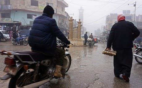 A Syrian man rides his motorcycle past a pedestrian in the village of Kafranbel in the northwestern province of Idlib on November 24, 2018. Muhammad Haj Kadour/AFP