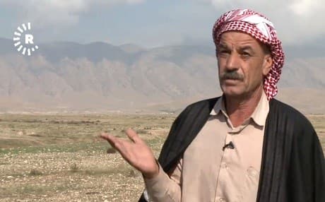 Khodida Khalaf, a Yezidi man from Tal Azer, gestures while explaining how rain has washed away some remains of people from his village buried in a mass grave. Photo: Rudaw