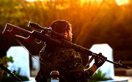 A Syrian Democratic Forces fighter holds a sniper rifle on his shoulder as he attends the funeral of a slain People's Protection Units (YPG) commander in Qamishli on December 6, 2018. Photo: Delil Souleiman | AFP