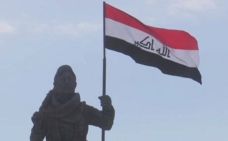 The Iraqi flag flies over the Peshmerga statue that stands at the northern entrance to Kirkuk. Photo: Rudaw