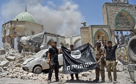 In this photo taken on June 30, 2017, members of the Iraqi Counter-Terrorism Service (CTS) hold an ISIS flag upside-down, outside the destroyed al-Nuri Mosque in the Old City of Mosul. File photo: Fadel Senna/AFP