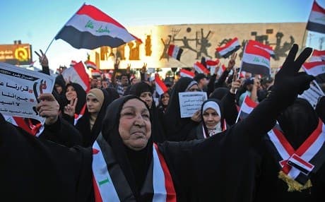 Followers of the Iraqi Shiite cleric Moqtada al-Sadr raise banners and national flags as they demonstrate in central Baghdad on December 14, 2018. Photo: Ahmad al-Rubaye/AFP