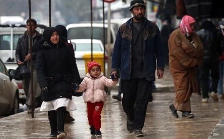 Syrians walk in the northern town of Manbij on Turkish border on December 30, 2018. Turkey is threatening an attack on the city. Photo: Delil Souleiman/AFP