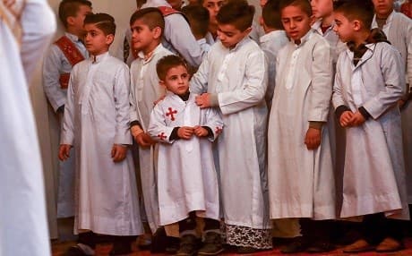 Young acolytes stand together as they attend Christmas morning mass at the Syriac Orthodox Church of the Virgin Mary in Qamishli in northeastern Syria on December 25, 2018. Photo: Delil Souleiman/AFP