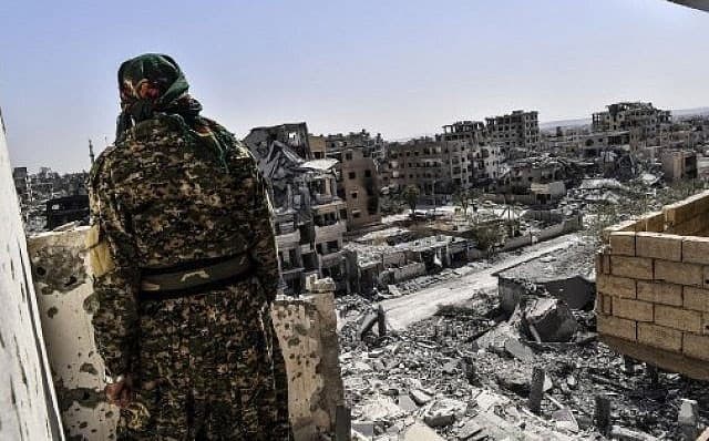 A member of the SDF looks out over western Raqqa, October 2017. File photo: Bulent Kilic / AFP
