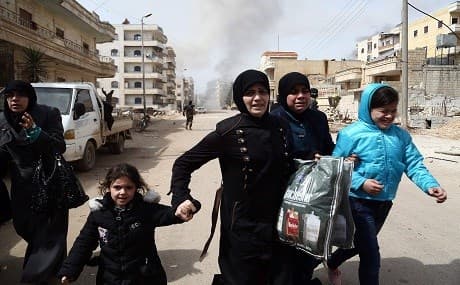 Civilians run for cover from explosions in the city of Afrin on March 18, 2018. File photo: Nazeer al-Khatib / AFP