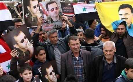 Afrin residents welcome arrival of Syrian regime forces with posters of President Bashar al-Assad and PKK founder Abdullah Ocalan, February 2018. File photo: Ahmad Shafie Bilal / AFP