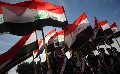Iraqi police hold their national flag and march during a parade in Baghdad on January 10, 2019 to mark the graduation of 158 Iraqi policemen after a six-month training period. Photo: Ahmed al-Rubaye | AFP