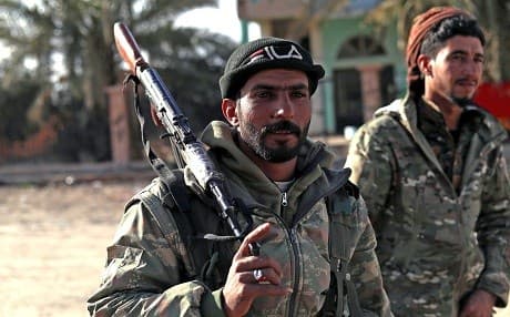 SDF fighters stand guard in the front line village of Baghouz. Photo: Delil Souleiman/AFP