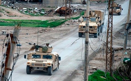 Vehicles belonging to the US-led coalition drive down a street in the frontline Syrian village of Baghuz, February 17, 2019. Photo: Fadel Senna / AFP 