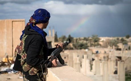 A member of the US-backed Syrian Democratic Forces stands guard on top of a building in Baghouz during an operation against the Islamic State group. Photo: AFP/Fadel Senna