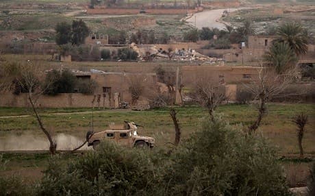 A military vehicle with the US-backed Syrian Democratic Forces rides through the Syrian village of al-Baghouz on February 19, 2019. Photo: Delil Souleiman | AFP