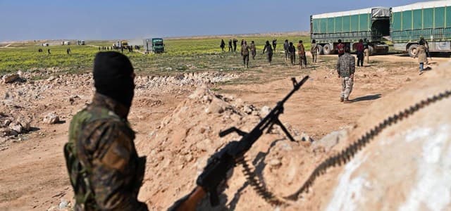 A Syrian Democratic Forces fighter stands guard as ISIS and their families leave al-Baghouz in Syria's Deir ez-Zor governorate on February 20, 2019. Photo: Bulent Kilic | AFP