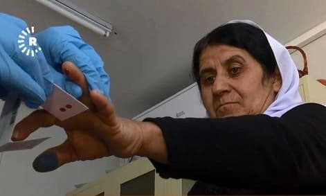 Yezidi woman is taking blood sample to help her find missing family members. Photo: Rudaw video