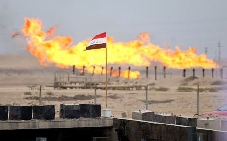 An Iraqi flag flies in front of excess gas as its being burnt off in at an oil refinery in the Zubair oil field southwest of Basra, Iraq. File photo: Haidar Mohammed Ali | AFP
