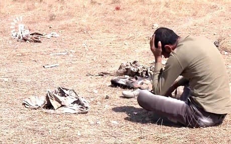A man weeps beside a mass grave in the Shingal area in June 2018. File photo: Rudaw