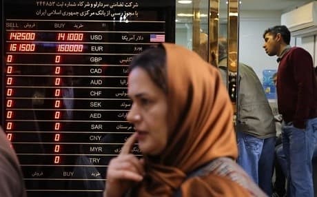 A woman walks past a currency exchange shop in Tehran's grand bazaar on November 3, 2018. Photo: Atta Kenare | AFP