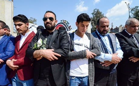 Iraqi men pray for the victims of the capsized ferry in the northern Iraqi city of Mosul, March 22, 2019. Photo: Zaid al-Obeidi / AFP 