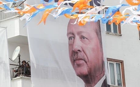 Women sit on a balcony next to a portrait of Turkish President Recep Tayyip Erdogan during a AKP (Justice and Development Party) campaign rally ahead of local elections in Ankara, Turkey, on March 28, 2019. Photo: Adem Altan/AFP
