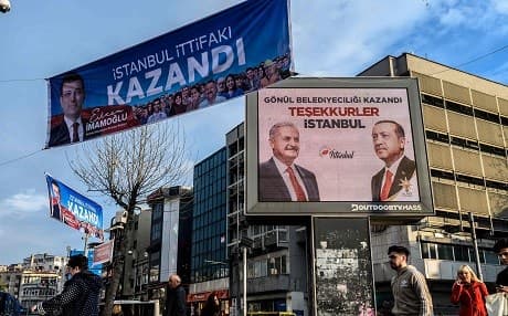 A banner (left) with a picture of CHP mayoral candidate Ekrem Imamoglu reading "Istanbul alliance has won" hangs next to a billboard (right) reading "Municipality has been won with heart, Thank you Istanbul" and portraying AKP ruling party mayor candidate Binali Yildirim and President Recep Tayyip Erdogan in Istanbul on April 9, 2019. Photo: Bulent Kilic/AFP