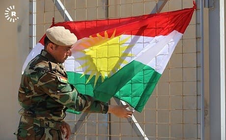 A Peshmerga soldier hangs a Kurdistan flag at a base in Baharka, Kurdistan Region, on March 19, 2018. File photo: Rudaw