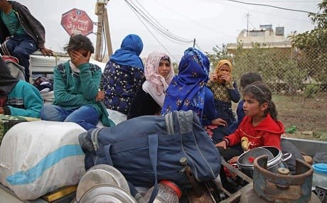 A Syrian family, riding in the back of a truck loaded with belongings, flee from reported regime shelling on Hama and Idlib provinces on May 1, 2019. Photo: Aaref Watad/AFP