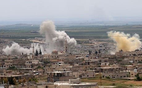 Smoke rises above buildings during shelling by Syrian regime forces and their allies on the town of Khan Sheikhun in the southern countryside of rebel-held Idlib province on May 11, 2019 (AFP Photo/Anas AL-DYAB)