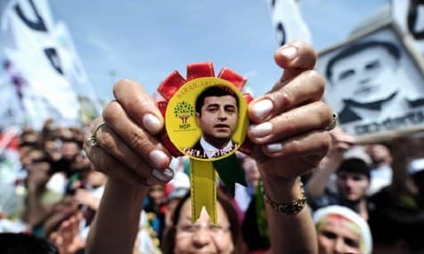 A woman holding a badge bearing the face of Selahattin Demirtaş, during an election rally in May 2015.  Photo: Ozan Kose/AFP/Getty Images