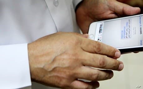 An Arab man displays an Apple iPhone to journalists in Ajman, United Arab Emirates, on August 25, 2016. File photo: AP