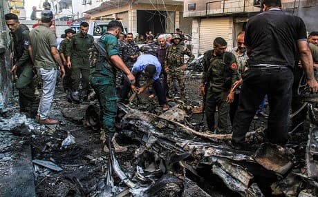 Kurdish security forces inspect the wreckage of a rigged car which detonated outside the Syriac Orthodox Church of the Virgin Mary in the predominantly Christian neighbourhood of al-Wasti in the Kurdish-majority city of Qamishli in northeast Syria on July 11, 2019. Photo: Muhammed Ahmad | AFP