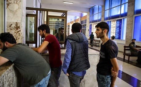 Incoming Syrian refugees who were suddenly deported from Turkey queue up to register with officials as they re-enter Syria, at the Bab al-Hawa crossing between Turkey and Syria's northwestern Idlib province on July 24, 2019. Photo: Aaref Watad | AFP