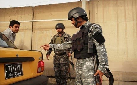 In this undated photo an Iraqi police officer searches a car in Baghdad, Iraq. Photo: Spencer Platt | AFP