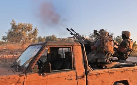 Fighters from Syria's former al-Qaeda affiliate Hayat Tahrir al-Sham (HTS) firing an anti-aircraft gun in Idlib on August 7, 2019. Photo: AFP/Omar Haj Kadour 