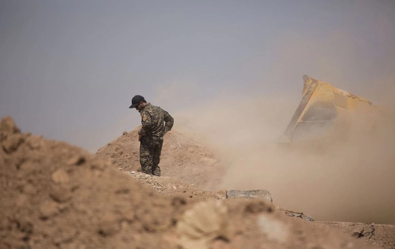 A member of the Tal Abyad Military Council, an affiliate of the U.S.-backed Syrian Democratic Forces, oversees the removal of a fortification in the safe zone between Syria and the Turkish border near Tal Abyad, Syria, Friday, Sept. 6, 2019. Photo: AP/Maya Alleruzzo