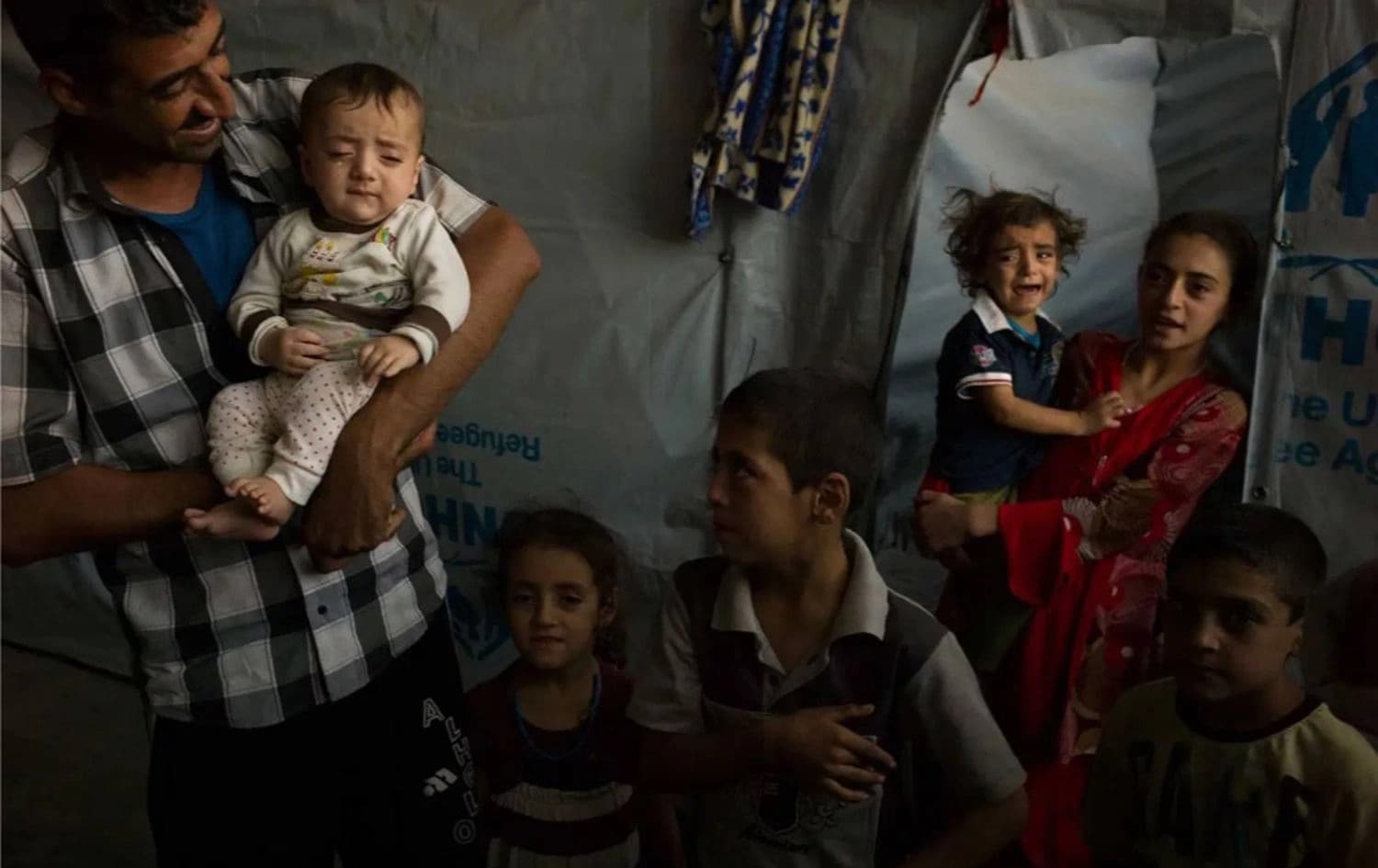 A displaced Iraqi family outside their tent in Bakarka Camp, Erbil province, February 2015. Photo: Dominic Nahr / UNHCR