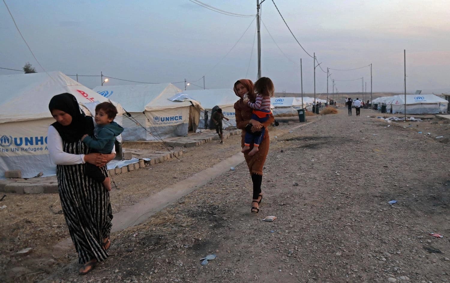 Syrian refugees walk past tents in Bardarash camp near Dohuk, Kurdistan Region of Iraq, October 18, 2019. Photo: Safin Hamed / AFP