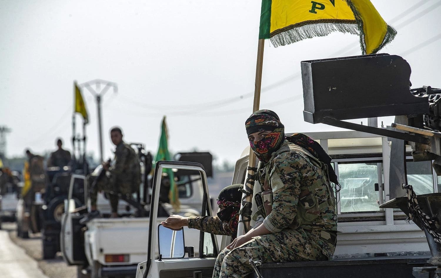 Fighters from the Syrian Democratic Forces (IDF) gather in their military vehicles as they withdraw from the Sanjak Saadoun border area near the northern Syrian town of Amuda, October 27, 2019. Photo: Delil Souleiman / AFP 