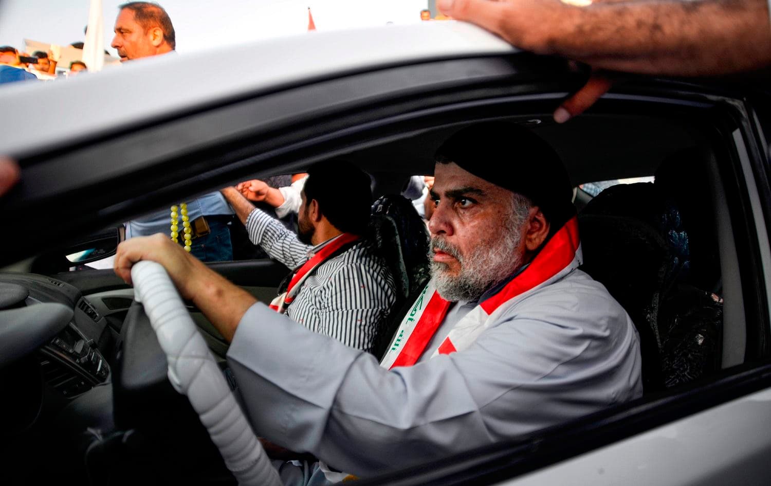 Iraqi Shiite cleric Muqtada al-Sadr drives a car as he joins anti-government demonstrators gathering in the central holy city of Najaf, October 29, 2019. Photo: Haidar Hamdani / AFP 